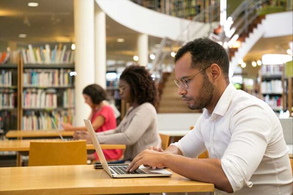 adults working on laptops in a library